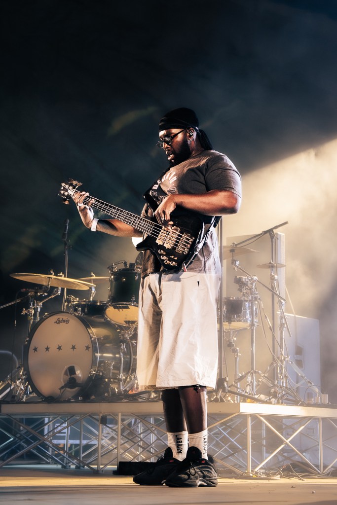Festivalle 2026, Ezra Collective on stage. The bassist TJ Koleoso with drums in the background